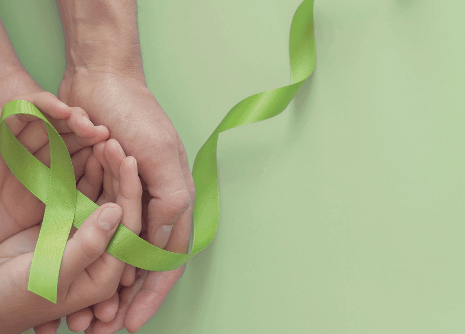 Hands holding a green Mental Health Awareness ribbon